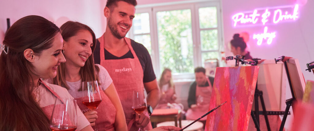 Personen beim Paint & Drink begutachten ihr Werk