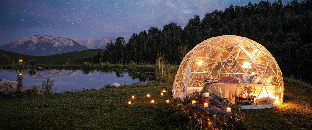 Schön beleuchtetes Bubblehotel am See in der Natur