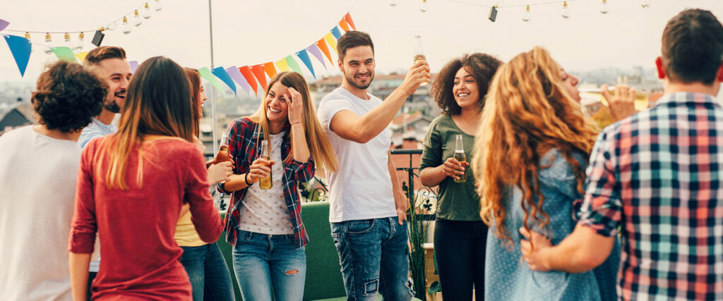 Personen auf einer Dachterrasse auf einer Firmenfeier in lockerer Stimmung