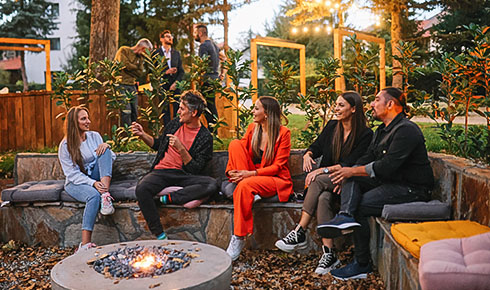 Personen bei Firmen-Offsite gemeinsam am Lagerfeuer