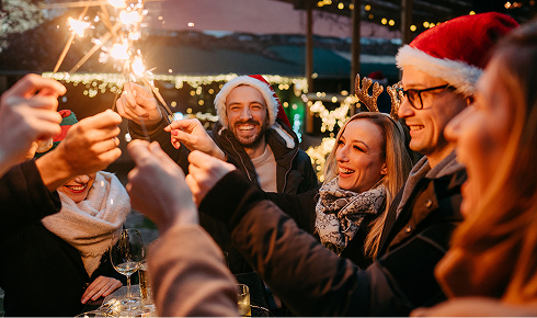 Team mit Wunderkerzen auf einem Weihnachtsmarkt.