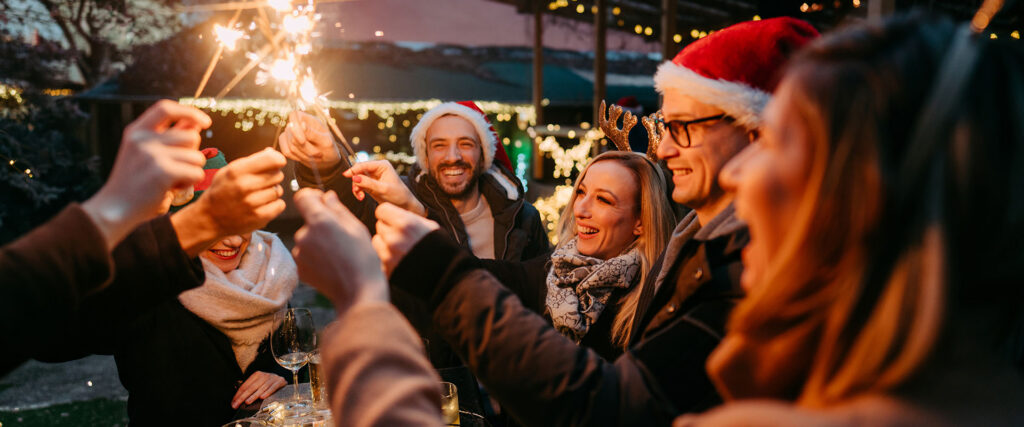 Team mit Wunderkerzen auf einem Weihnachtsmarkt.